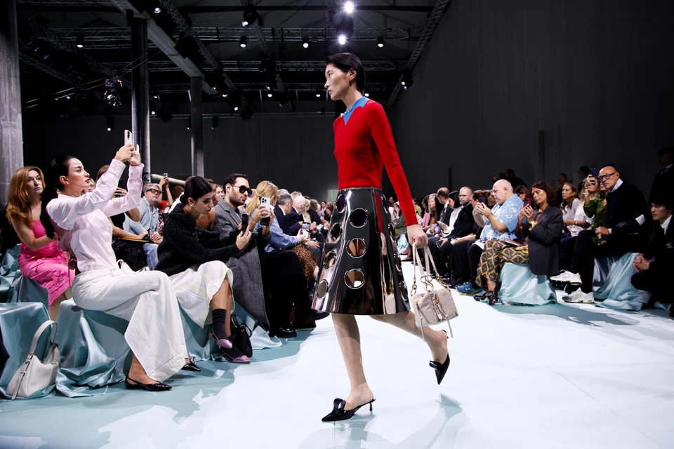 Models wore stiff shiny silver skirts, some bearing see-through decorative holes (top), colourful tights that morphed into trousers and tailored trousers as well as skirts that hung from belts.