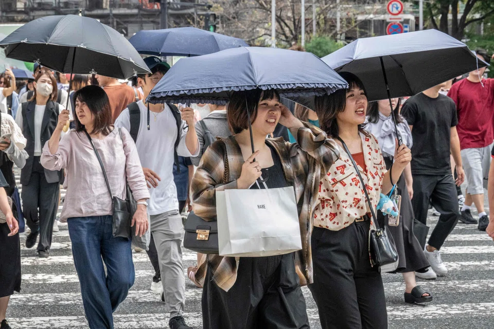 People use parasols to shelter from the sun while walking along a street in Tokyo, Japan, Sept 19, 2024. Across the archipelago, the month’s average temperature was 2.52 deg C higher than usual, the Japan Meteorological Agency said on Tuesday.