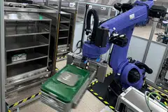 A three-arm robotic system, coupled with four Vertical Carousel Systems, automates the storage and retrieval of instrument sets.