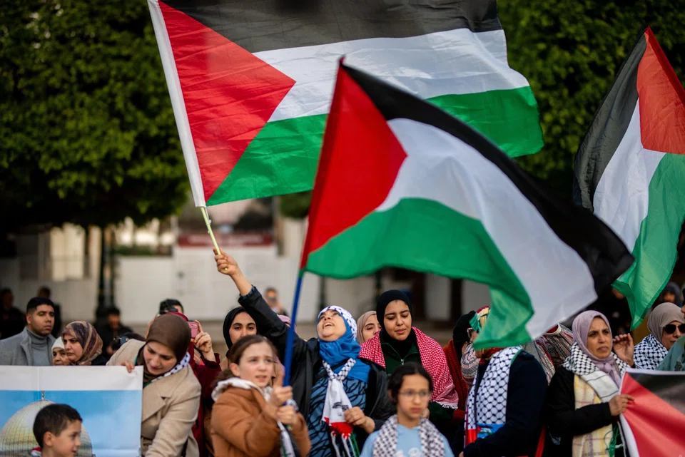 Protesters wave Palestinian flags during a demonstration in solidarity with the Palestinian people amid the ongoing conflict between Israel and Hamas, demanding the severing of ties with Israel, in Parliament Square in Rabat, Morocco, Jan 2, 2024. 