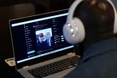 A person tries to watch on a laptop billionaire entrepreneur Elon Musk's interview with Republican presidential candidate and former US President Donald Trump on the X social media network, New York City, US, Aug 12, 2024.  