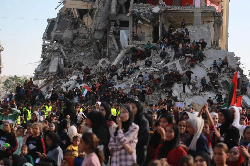Palestinians gather on the rubble of building destroyed by the Israeli military to watch and celebrate the mass wedding of 54 couples.