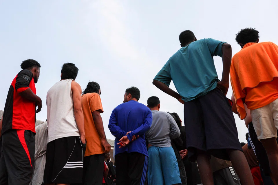 Victims of scam centres, who were trafficked into working in Myanmar queue for food at a shelter inside the 310th Military District as they wait for their embassies to pick them up, Tak province, Thailand, Feb 19, 2025. 
