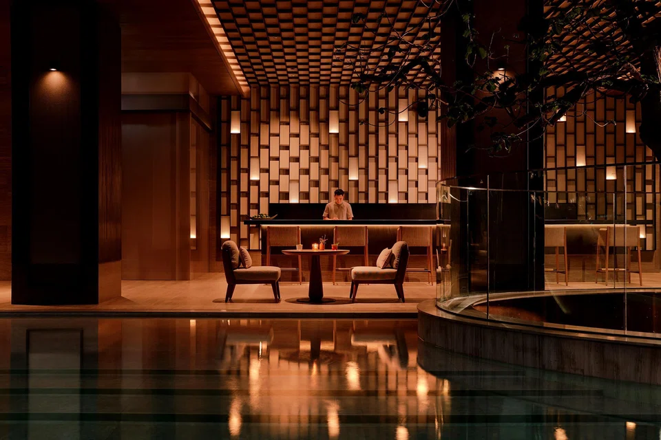 The pool at Aman Nai Lert Bangkok, wrapped in timber, water and shadow.