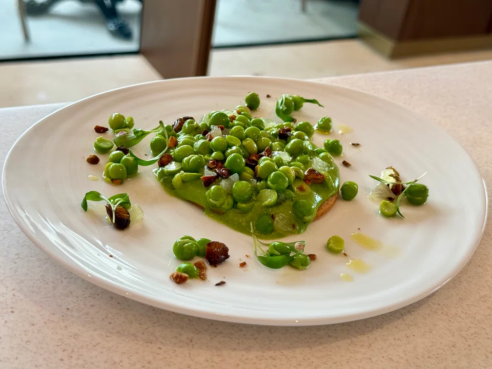 The fresh pea tart has a mix of fresh and blended peas on a thin, sable-like pastry crust, with tart grapefruit bits and roasted crushed nuts for crunch. 