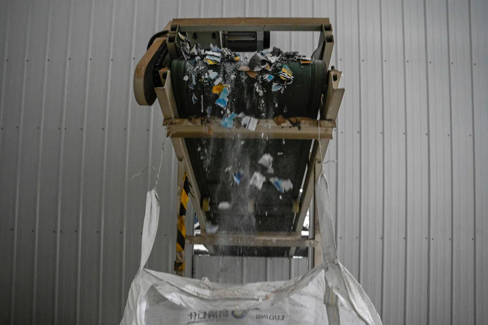Pieces of wedding photos leaving a conveyor belt after being put into a shredding machine at a warehouse in Langfang, in northern China's Hebei province. 