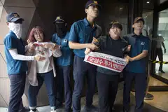 Police officials detain university student protesters who had tried to enter the Japanese embassy in Seoul, South Korea, on Thursday. The students had held a rally to oppose Japan's discharge of treated radioactive water from its crippled Fukushima nuclear power plant into the ocean.