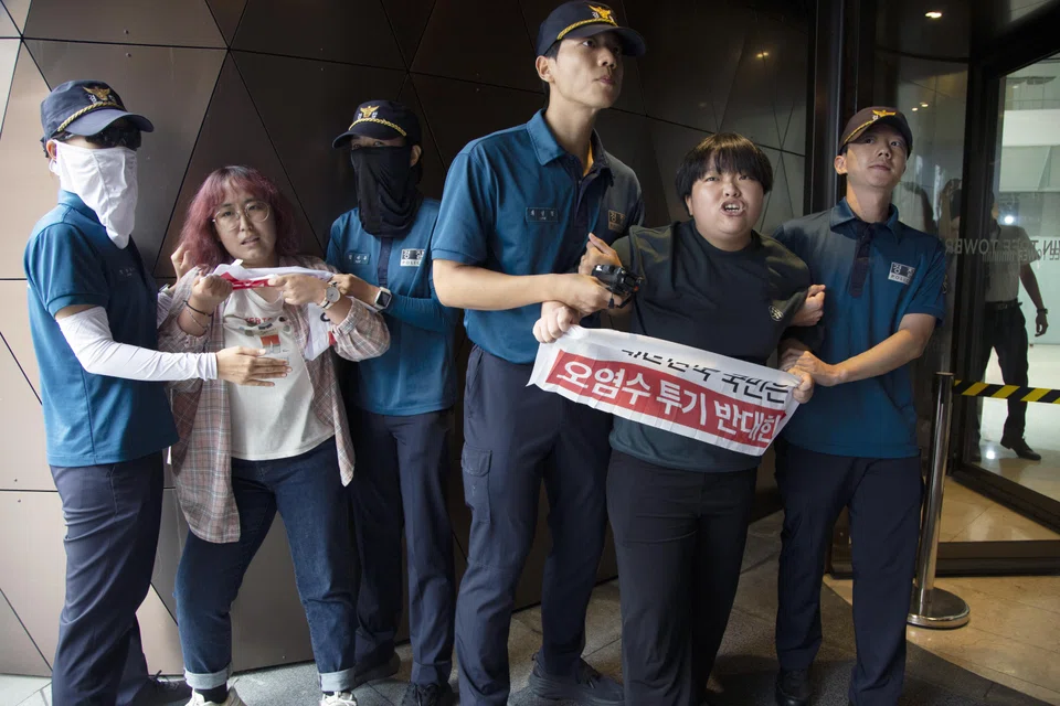 Police officials detain university student protesters who had tried to enter the Japanese embassy in Seoul, South Korea, on Thursday. The students had held a rally to oppose Japan's discharge of treated radioactive water from its crippled Fukushima nuclear power plant into the ocean.