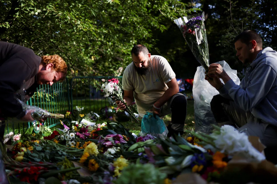 Volunteers remove packaging from floral tributes, following the funeral of Britain's Queen Elizabeth, in Green Park in London, Britain Sep 20, 2022. 