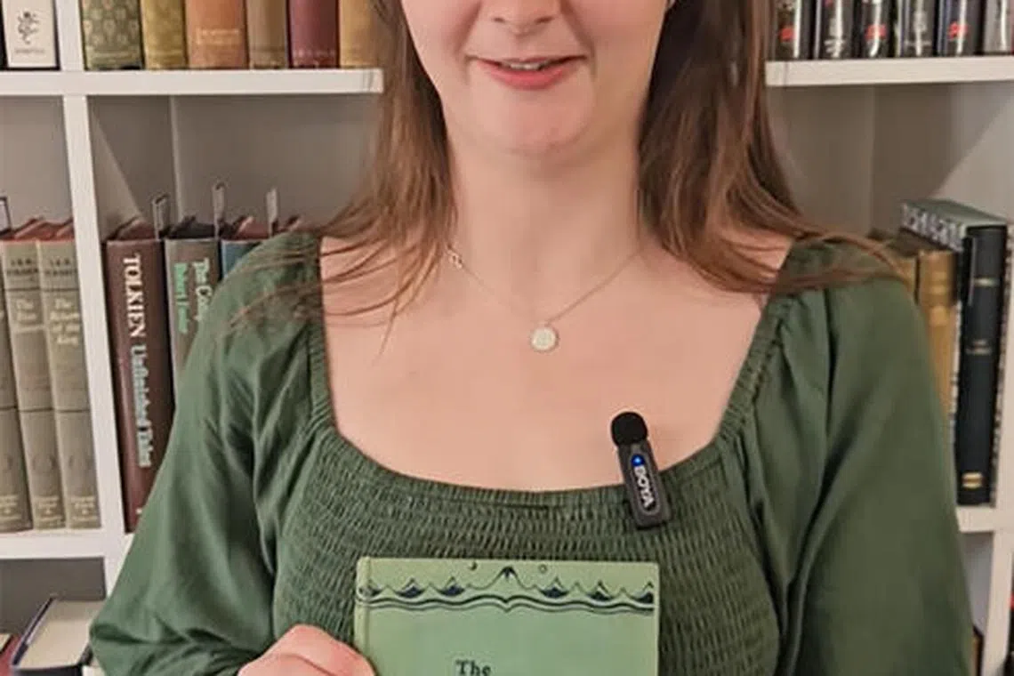 Caitlin Riley, a rare books specialist, poses with one of the first editions of The Hobbit by J.R.R. Tolkien which was discovered in a home library of a cleaned-out house in Bristol.