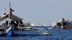 China Coast Guard vessels patrol past Philippine fishing boats at the disputed Scarborough Shoal, April 5, 2017. The sanctions will also target about 170 Chinese entities for what Washington considers illegal fishing in the Pacific, the US officials said.