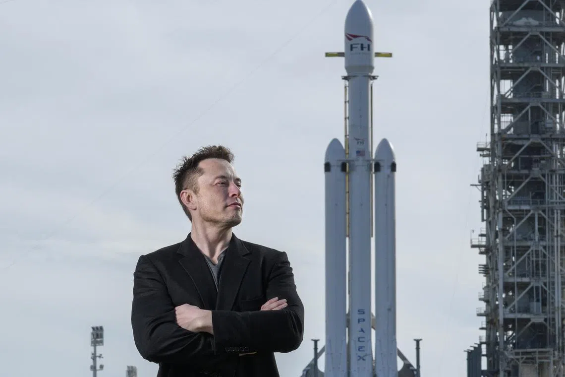 FILE Ñ Elon Musk poses with the SpaceX Falcon Heavy rocket, at NASA's Kennedy Space Center in Cape Canaveral, Fla., Feb. 5, 2018. In emails to workers at SpaceX and Tesla, Musk said workers were required to spend a minimum of 40 hours a week in the office. (Todd Anderson/The New York Times)