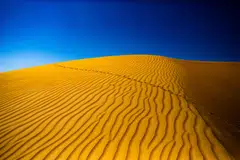 Oman’s golden deserts under impossibly blue skies.