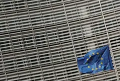 A European Union flag flutters outside the European Commission headquarters in Brussels, Belgium. 