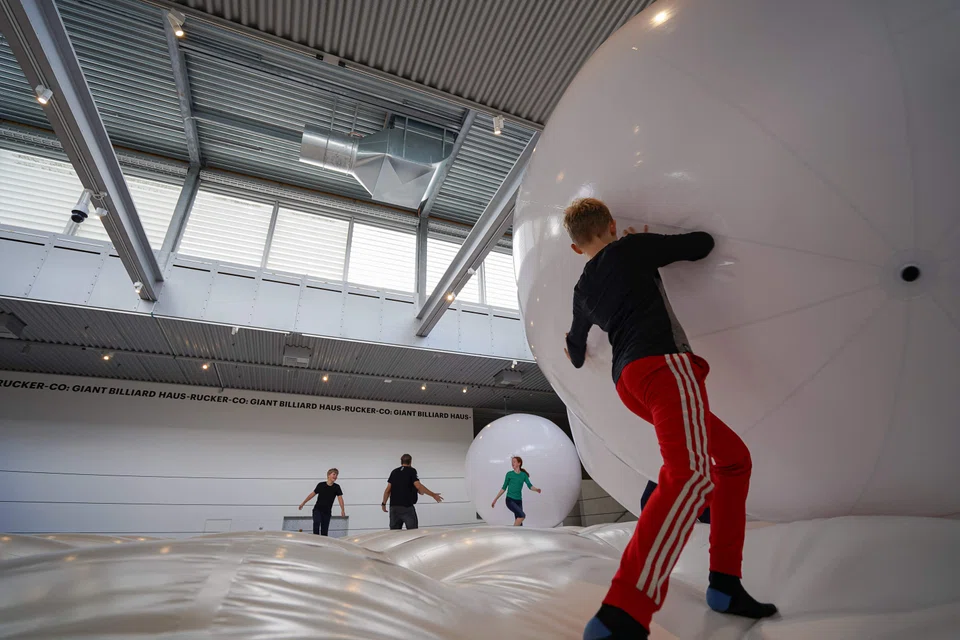 In ‘Giant Billiard', visitors bob three large, inflatable balls across a white mattress.