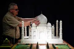 Visually impaired Jose Pedro Gonzalez touches the model of the Taj Mahal with his hands.