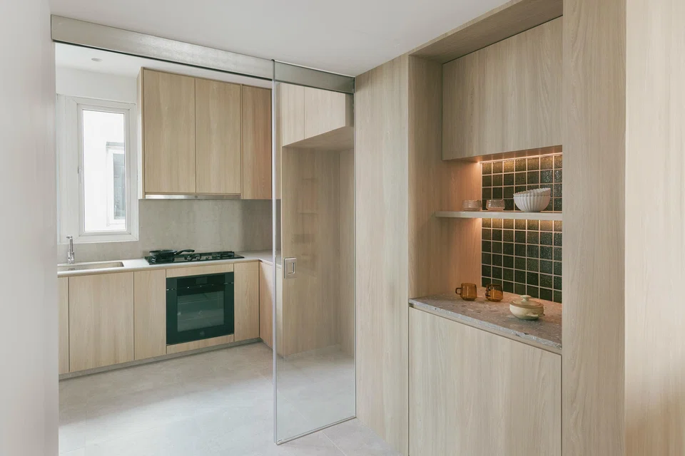 The kitchen, formerly enclosed, now enjoys more light with larger openings and a sliding glass door.  