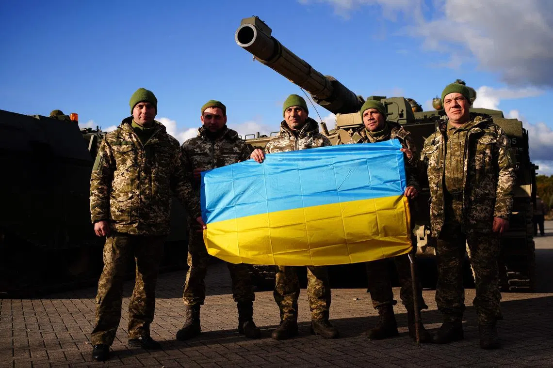 Ukrainian soldiers who are undergoing training at Bovington Camp, a British Army military base in southwest England, pose in front of a FV 4034 Challenger 2 tank, during a visit by UK Defence Secretary Ben Wallace (not in photo) on Feb 22, 2023.