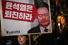 A woman holds a sign that reads "Yoon Suk-yeol should step down" during a candlelight vigil against South Korea President Yoon in Seoul, South Korea, Dec 4, 2024. South Korea's opposition moved to impeach Yoon after his extraordinary but short-lived imposition of martial law that brought thousands of protesters to the streets. 