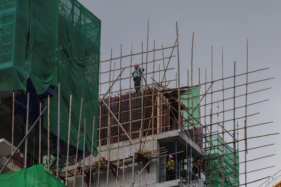 Construction workers work at a construction site for a residential development in Kai Tak, Hong Kong, China, May 6, 2025. REUTERS/Tyrone Siu