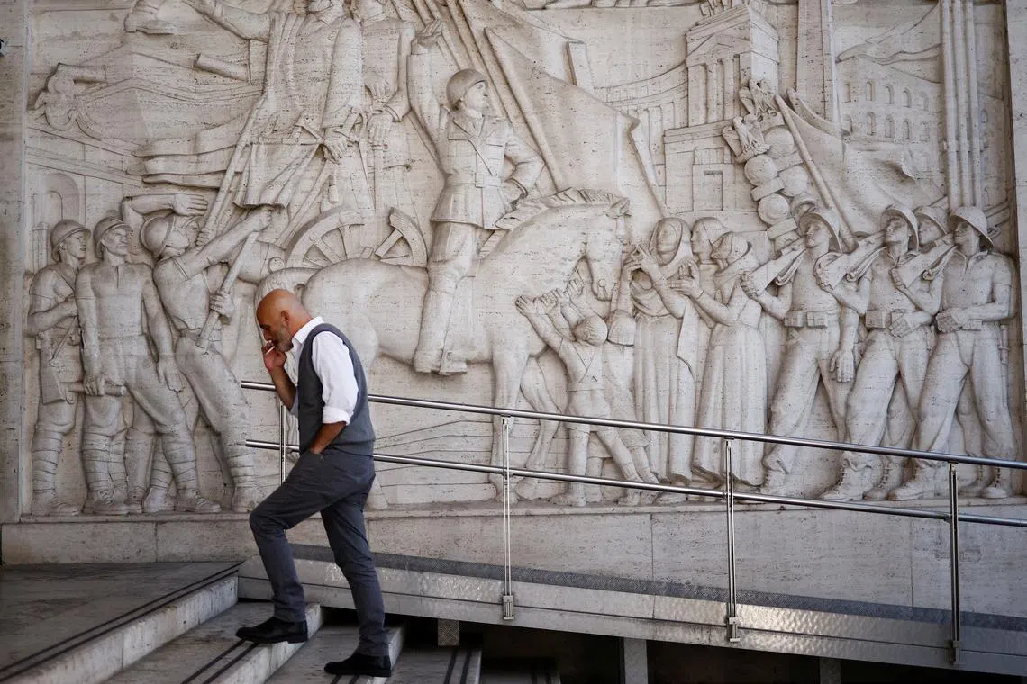 A man walks past a bas-relief depicting fascist leader Benito Mussolini at the EUR neighbourhood known for its fascist architecture in Rome, Italy, October 19, 2022.