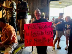 Production accountant Will Morris holds a sign at a "Stay in LA" rally in Sun Valley, California, April 6, 2025.