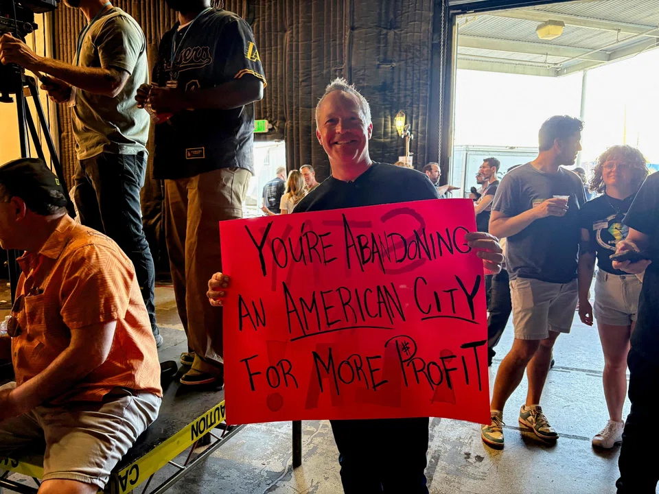 Production accountant Will Morris holds a sign at a "Stay in LA" rally in Sun Valley, California, April 6, 2025.