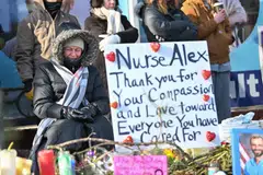 A woman mourns at a makeshift memorial for Alex Pretti in south Minneapolis, Minnesota, Jan 25, 2026. 