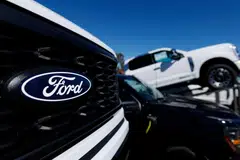 A Ford logo is pictured on a Ford F-150 pickup truck. The Detroit automaker said it will cancel plans for select larger EVs - including its F-150 Lightning - due to weak demand.