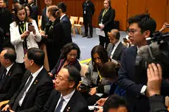 A Chinese official (right) tries to block cameras from filming Chinese-born Australian journalist Cheng Lei (seated in second row), who is attending a signing ceremony by Premier Li Qiang and Australian Prime Minister Anthony Albanese at the Australian Parliament House in Canberra, Australia, June 17, 2024.  