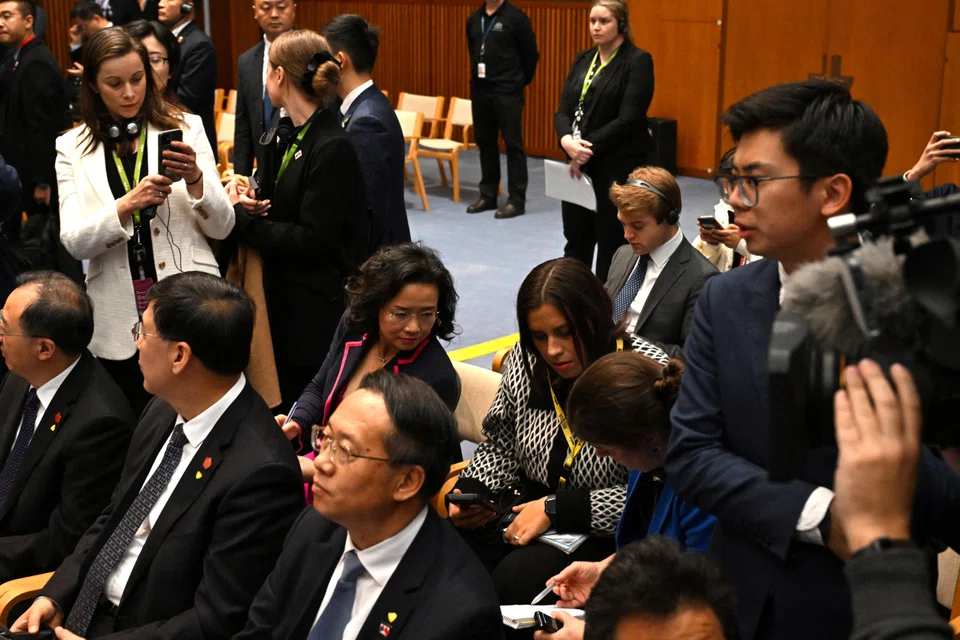 A Chinese official (right) tries to block cameras from filming Chinese-born Australian journalist Cheng Lei (seated in second row), who is attending a signing ceremony by Premier Li Qiang and Australian Prime Minister Anthony Albanese at the Australian Parliament House in Canberra, Australia, June 17, 2024.  