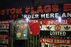 Flags are displayed at a makeshift stand outside Old Trafford. Manchester United are in 14th place in the EPL, 23 points behind their next opponents, Liverpool.