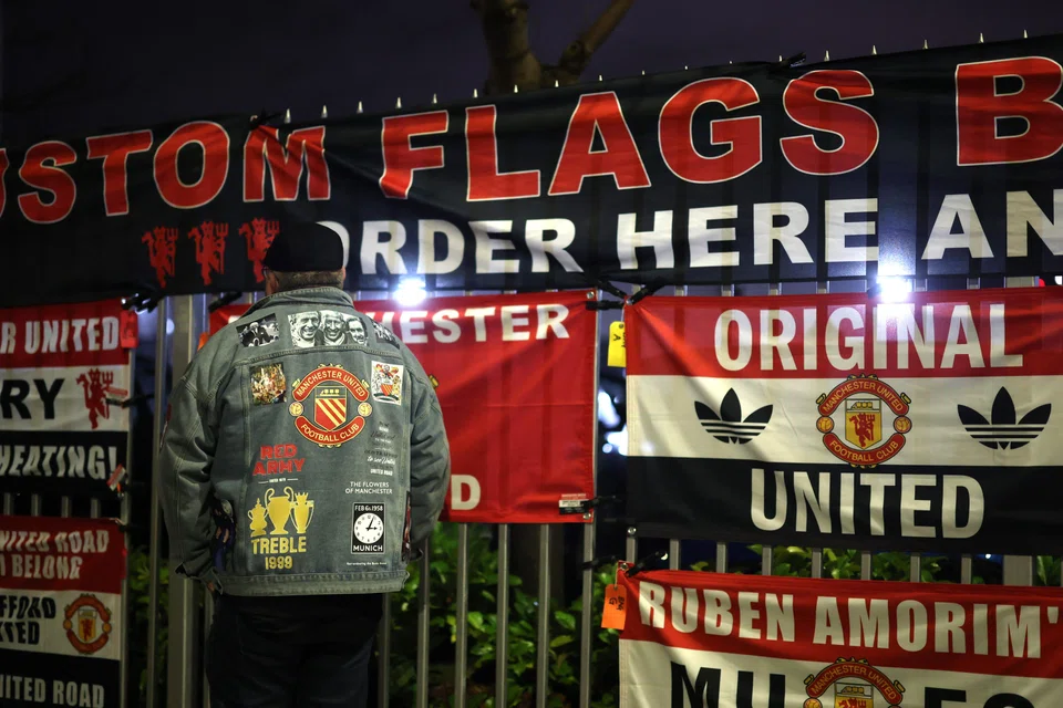 Flags are displayed at a makeshift stand outside Old Trafford. Manchester United are in 14th place in the EPL, 23 points behind their next opponents, Liverpool.