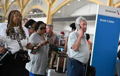 Passengers line up to check-in at Ronald Reagan Washington National Airport during a major worldwide computer systems outage. 