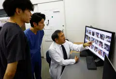 Nihon University professor and head of Nihon University Animal Medical Centre Kazuya Edamura, 49, gives a lecture on the diagnosis of pain in cats to students by using cat photos used to train the AI of 'CatsMe!', an AI-driven smartphone application.