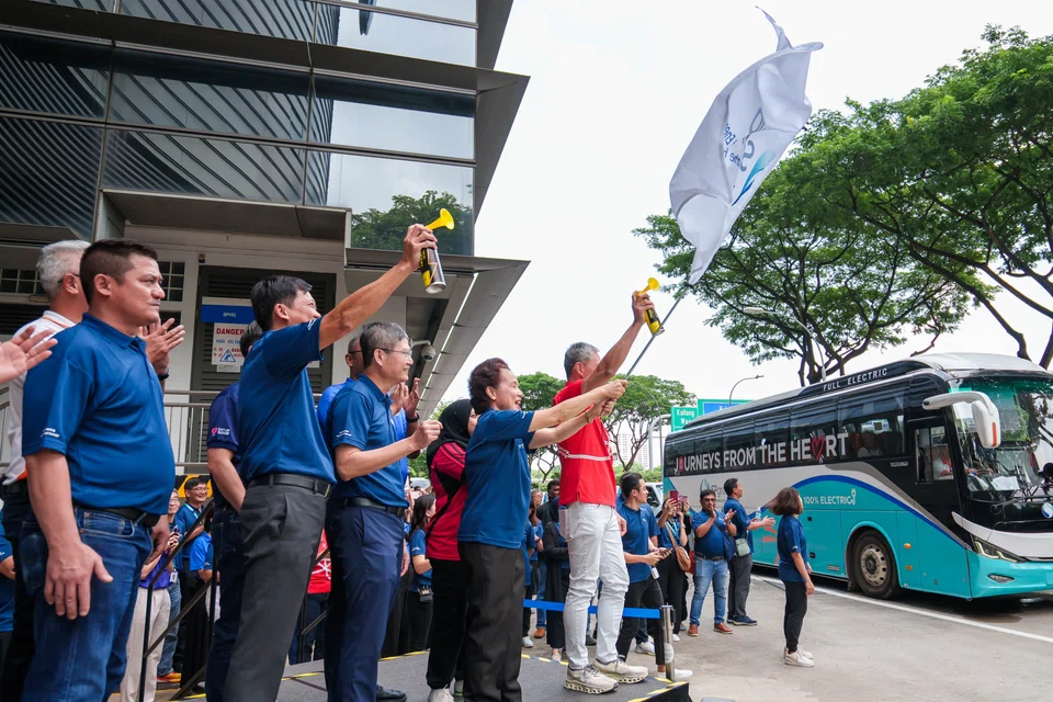 SP Group employees and the company's beneficiary social service agencies flagging off SG60 Journeys from the Heart at the SP Community Festival on Jun 4.