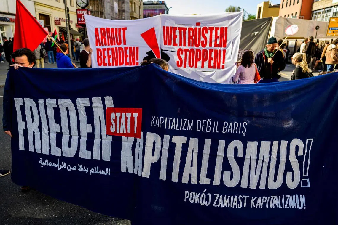 People hold a banner which reads "Peace not Capitalism!" during an anti-capitalism march in Berlin on Apr 30, the eve of May Day protests in the German capital.
