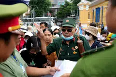 A Vietnam war veteran and fraud victim arrives with other victims to attend the court proceedings of property tycoon Truong My Lan in Ho Chi Minh City.