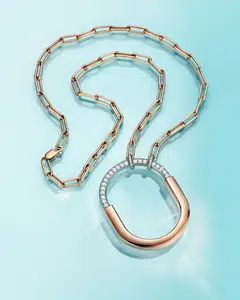 Lock by Tiffany pendants feature a striking oval link chain that echoes the padlock motif. Featured here is a Lock pendant in rose and white gold with diamonds. 