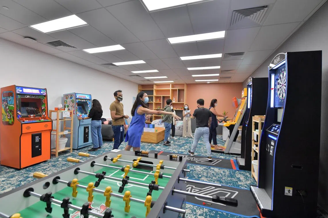 Meta employees making use of the games-room facilities in the company's Singapore office in May 2022.  Employers now routinely offer their staff perks such as free food, gym membership and flu  jabs. 