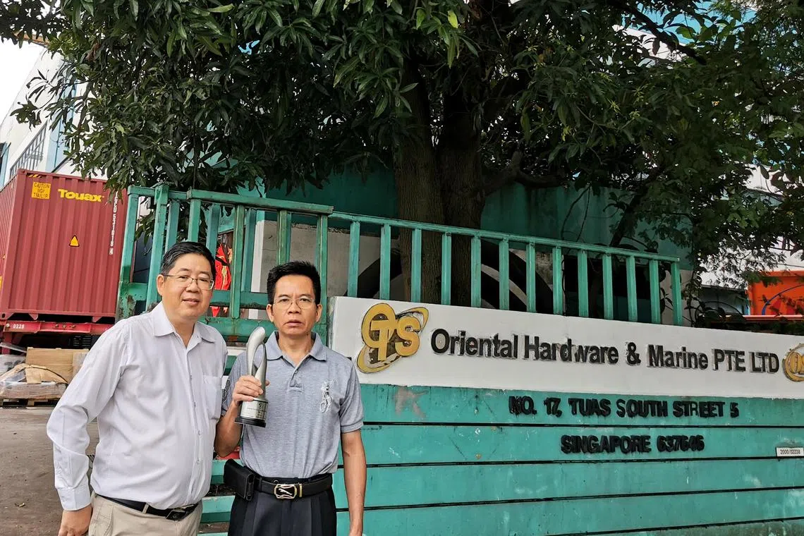 Oriental Hardware & Marine's international sales and safety manager Ken Lim (left) and managing director Lin Yong, with their Enterprise 50 award trophy from 2021.
