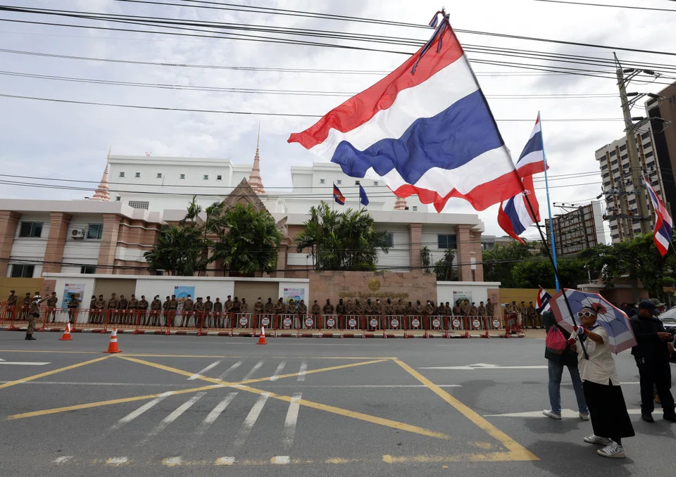 A person waves the Thai national flag during a protest rally amid the escalating Thai-Cambodian border dispute, outside the Cambodian Embassy in Bangkok on Jul 20.