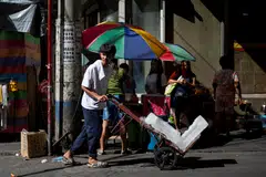 A worker pushes a trolley with ice blocks during a hot day at a market in Manila, Philippines, April 8, 2024. Philippines' annual inflation stood at 3.7 per cent in June, below the 3.9 per cent forecast in a Reuters poll.