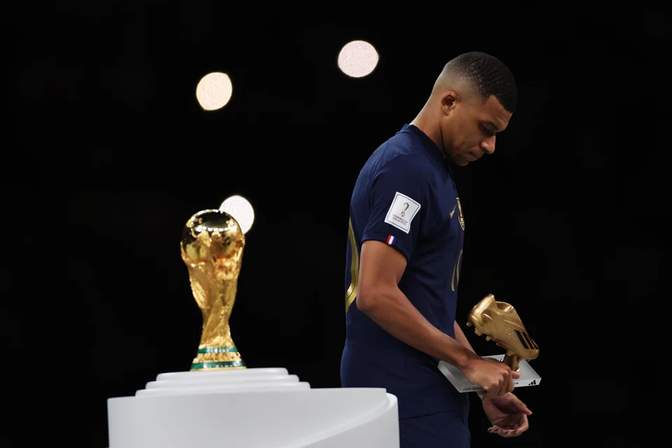 A dejected Kylian Mbappe of France passes by the World Cup trophy after winning the Golden Boot at the end of the tournament in Qatar.