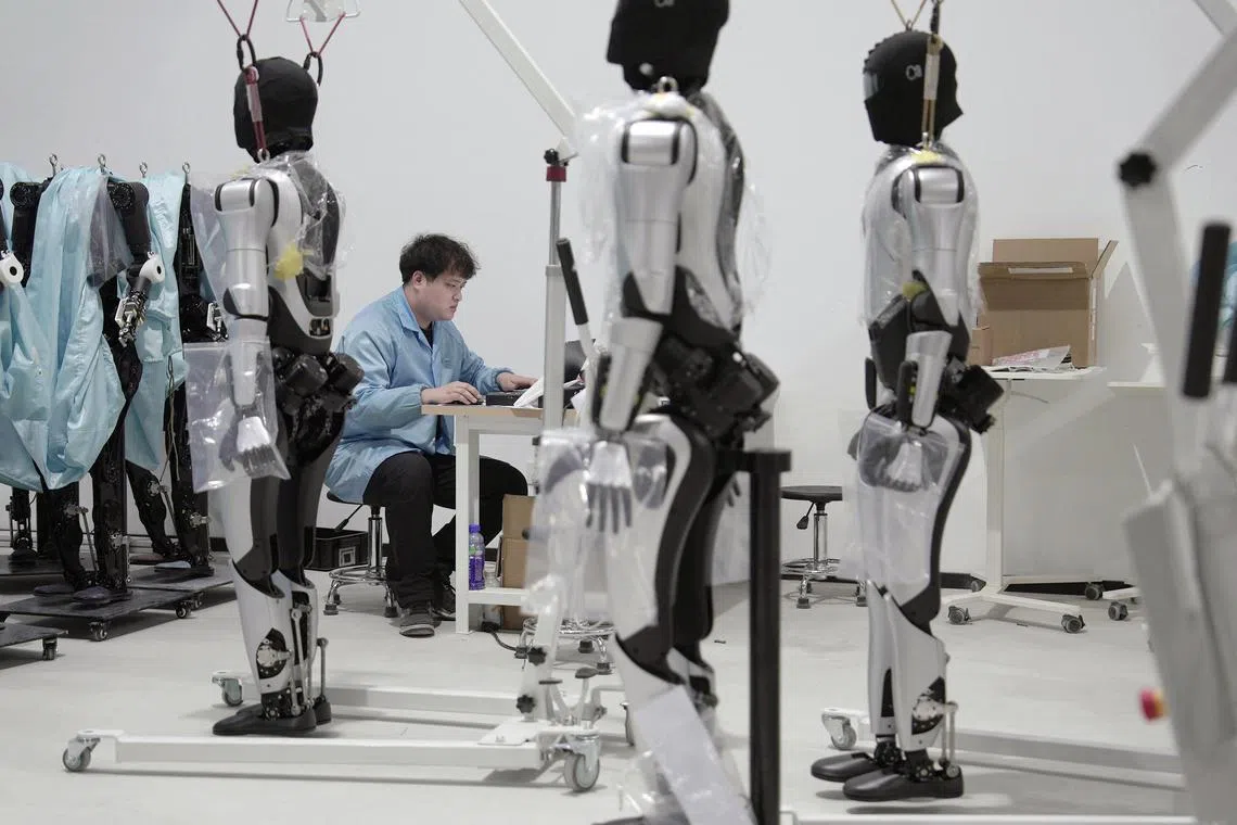 An engineer works on humanoid robots at an Agibot factory in Shanghai, China, March 12, 2025. 