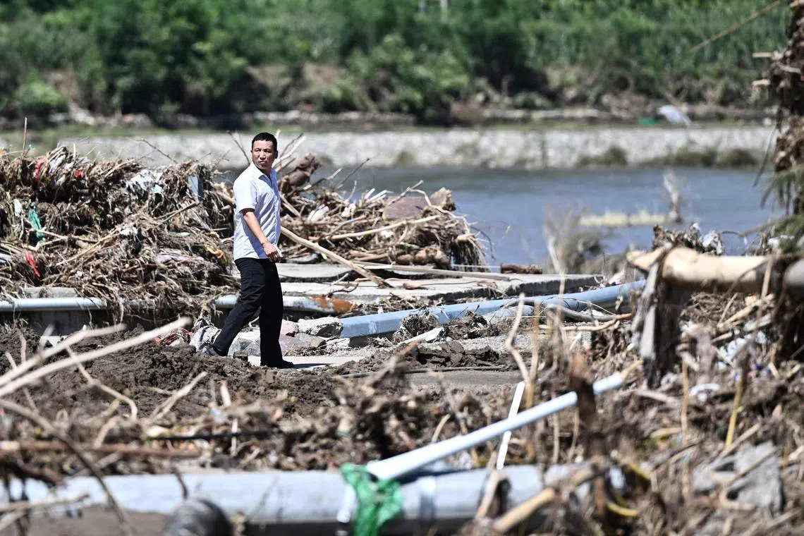 A man walks past a rain damaged area from the past few days in Huairou district, on the outskirts of Beijing, China, July 30, 2025. Heavy rain killed more than 30 people and forced authorities to evacuate tens of thousands as swaths of northern China were lashed by torrential downpours that sparked landslides and flooding, state media said. 