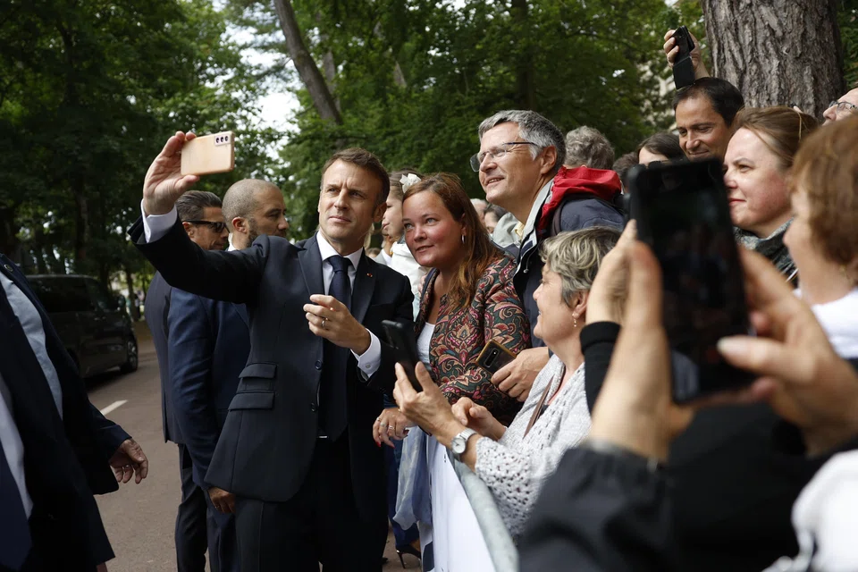 French President Emmanuel Macron greets supporters after casting his vote in the second round of French parliamentary elections at a polling station in Le Touquet-Paris-Plage, France, July 7, 2024. 