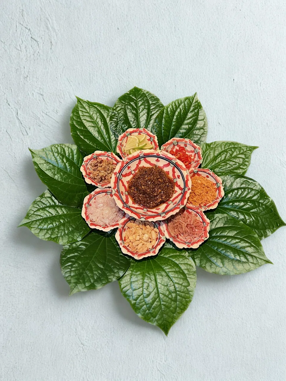 Miang kham features condiments wrapped in betel leaves.