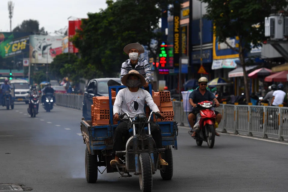 Workers transport construction materials on a street in Ho Chi Minh City. Vietnam's petrol industry has undergone sustained disruption in recent months, raising questions about the country's fuel pricing regulations.