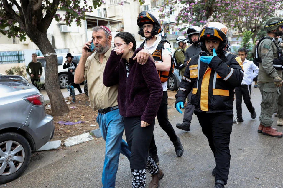 Israeli emergency personnel evacuating people from an impact site, after Iran launched missiles towards Israel, in Bnei Brak, on Apr 1.